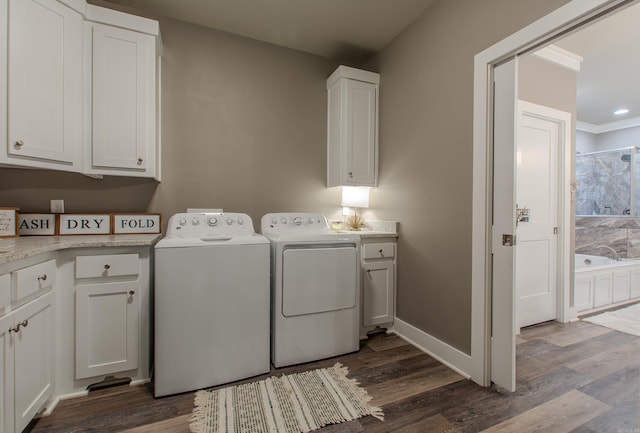 clothes washing area featuring cabinets, separate washer and dryer, and hardwood / wood-style floors