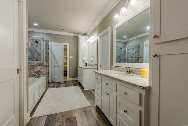 bathroom with shower with separate bathtub, wood-type flooring, ornamental molding, and vanity