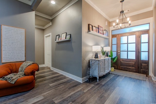 foyer with dark wood-type flooring, ornamental molding, and a chandelier