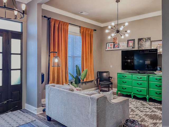 living room with crown molding, hardwood / wood-style floors, and a notable chandelier