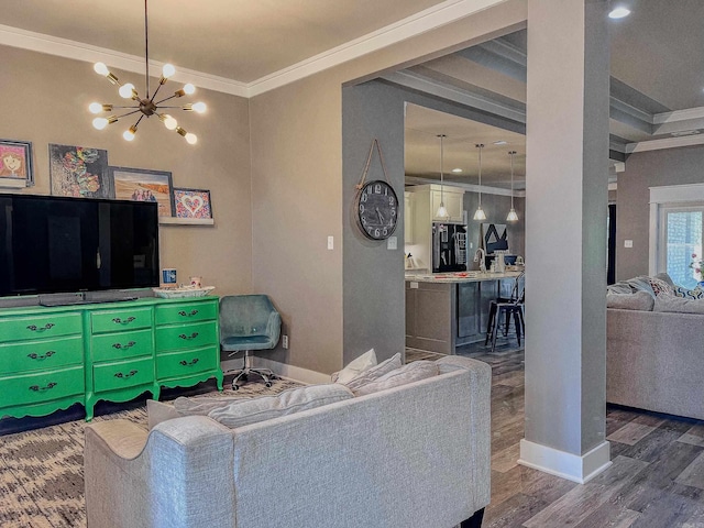 living room featuring dark hardwood / wood-style flooring, a notable chandelier, ornamental molding, and sink