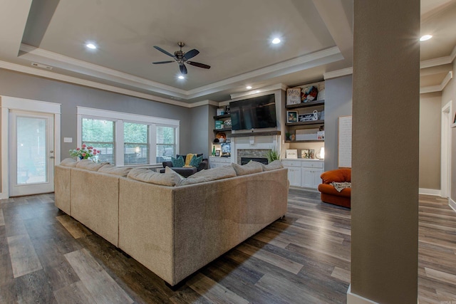 living room with crown molding, dark hardwood / wood-style flooring, and a tray ceiling