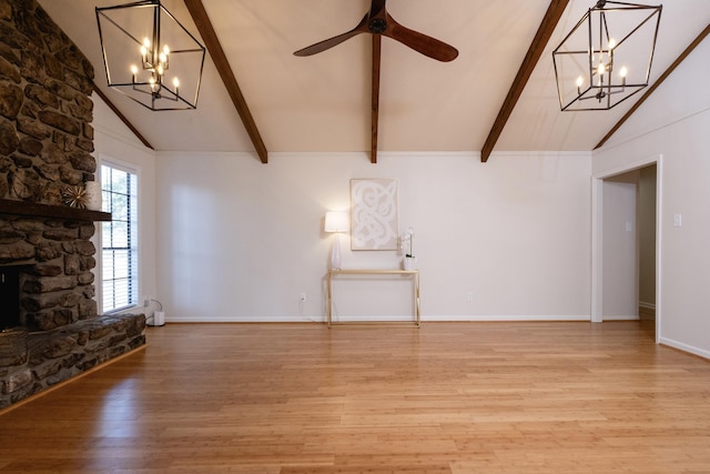 unfurnished living room featuring hardwood / wood-style flooring, ceiling fan, a fireplace, and lofted ceiling with beams