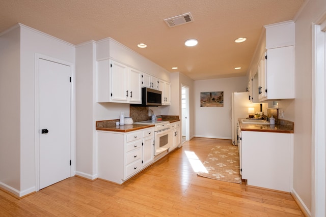 kitchen featuring sink, white electric range oven, light wood-type flooring, and white cabinets