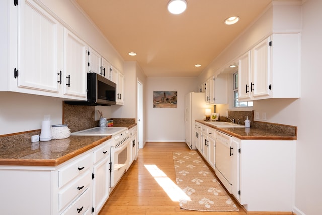 kitchen with light wood-type flooring, white appliances, sink, and white cabinets