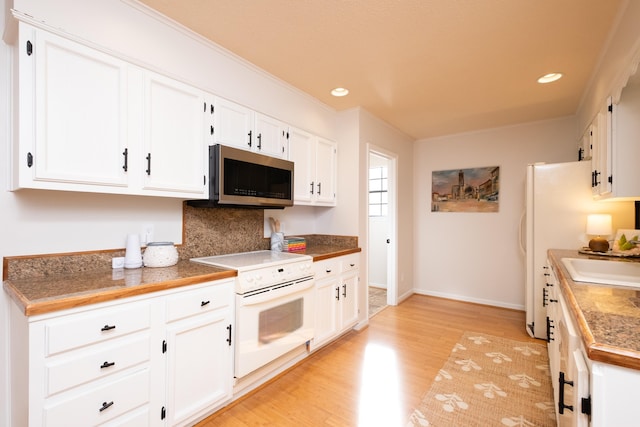 kitchen with electric stove, white cabinetry, sink, and light wood-type flooring