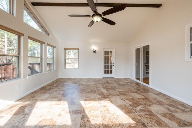 unfurnished sunroom featuring vaulted ceiling with beams, plenty of natural light, and ceiling fan