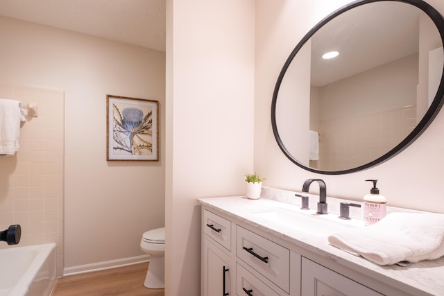 full bathroom with vanity, bathtub / shower combination, hardwood / wood-style floors, and toilet