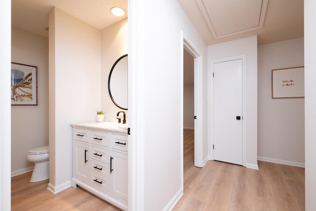 bathroom featuring vanity, hardwood / wood-style flooring, and toilet