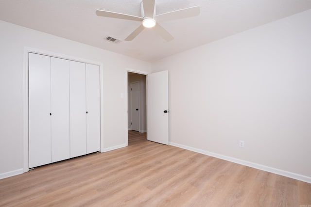 unfurnished bedroom featuring ceiling fan, a closet, and light hardwood / wood-style flooring