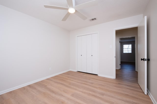 unfurnished bedroom featuring a textured ceiling, a closet, ceiling fan, and light wood-type flooring