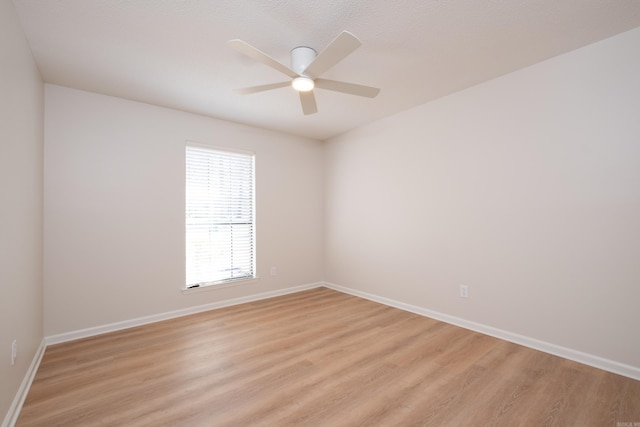 spare room with ceiling fan and light wood-type flooring