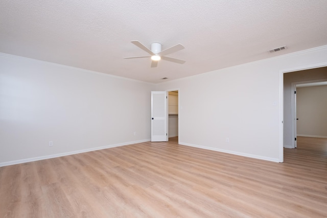 spare room with ornamental molding, light hardwood / wood-style floors, and a textured ceiling