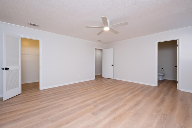 unfurnished bedroom featuring crown molding, light hardwood / wood-style flooring, and a textured ceiling