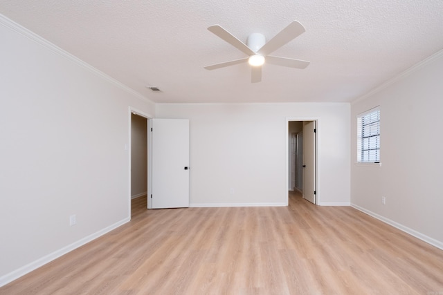 spare room featuring crown molding, a textured ceiling, and light hardwood / wood-style floors