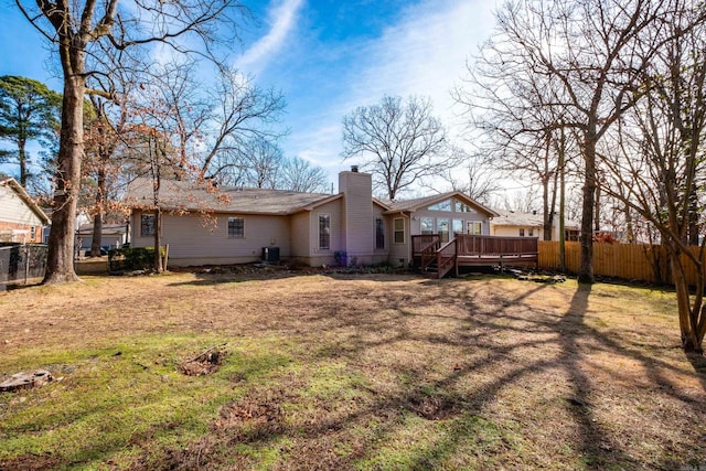 rear view of property featuring a yard, cooling unit, and a deck