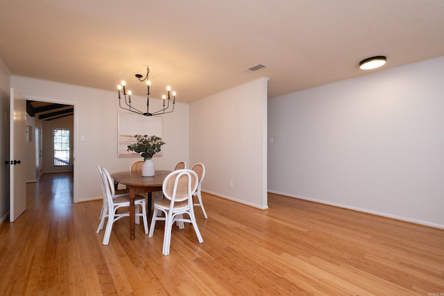 dining area featuring a notable chandelier, crown molding, and light hardwood / wood-style flooring