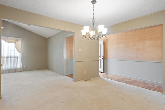 carpeted empty room featuring vaulted ceiling, a notable chandelier, and a textured ceiling