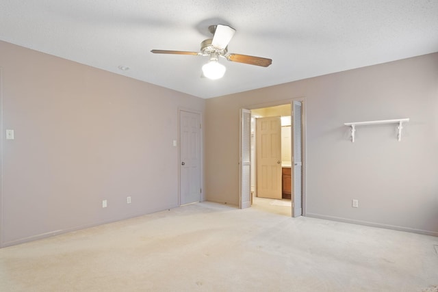 carpeted empty room with ceiling fan and a textured ceiling