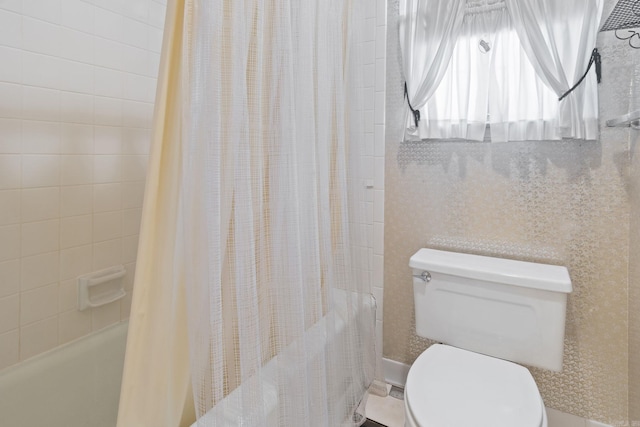 bathroom featuring shower / bathtub combination with curtain and toilet