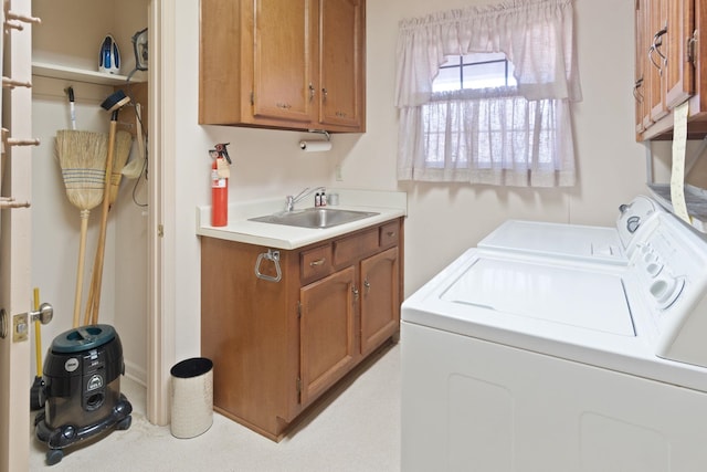 laundry area featuring cabinets, independent washer and dryer, and sink