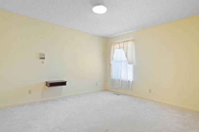 empty room featuring light carpet and a textured ceiling