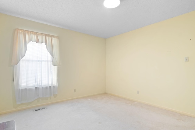 empty room featuring a textured ceiling and carpet