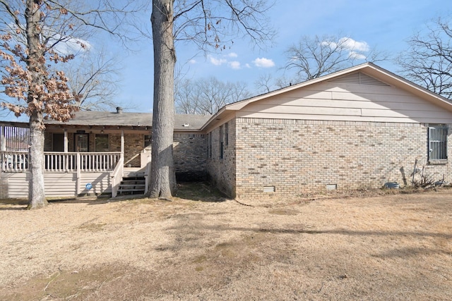 back of property with covered porch and a lawn