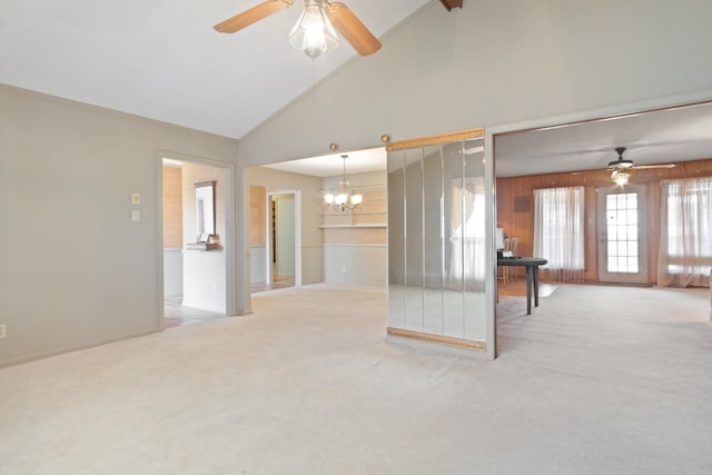 spare room featuring ceiling fan with notable chandelier, high vaulted ceiling, and carpet flooring