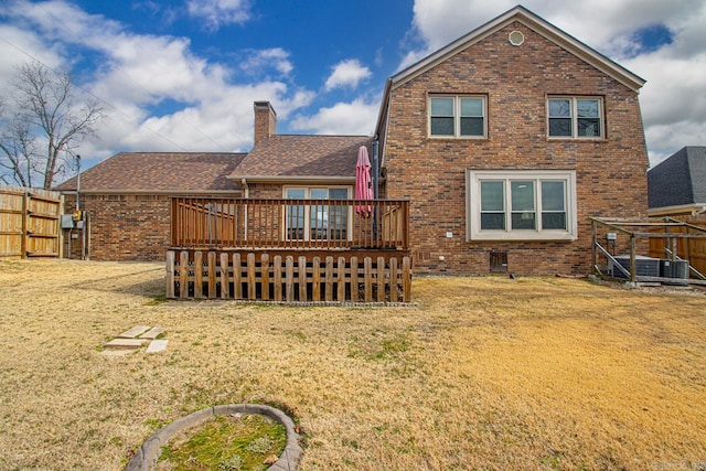 rear view of property featuring a yard and a deck