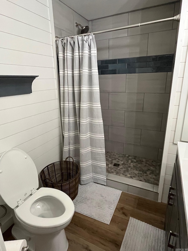 bathroom with walk in shower, toilet, and hardwood / wood-style flooring