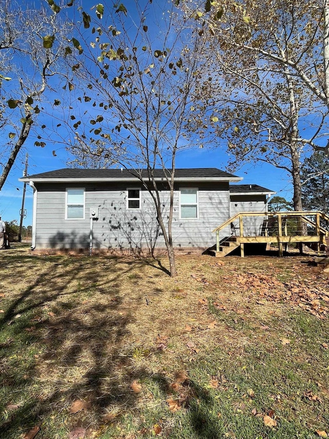 rear view of house featuring a yard and a deck