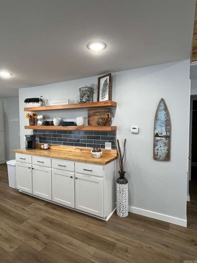 bar with white cabinetry, dark wood-type flooring, backsplash, and wood counters