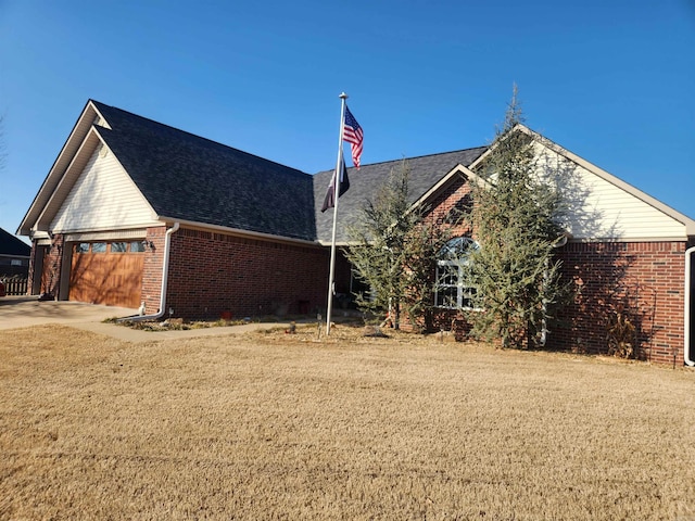 view of side of home featuring a garage and a yard