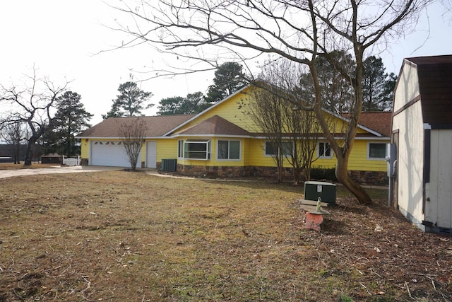 view of front of home with central AC unit and a garage