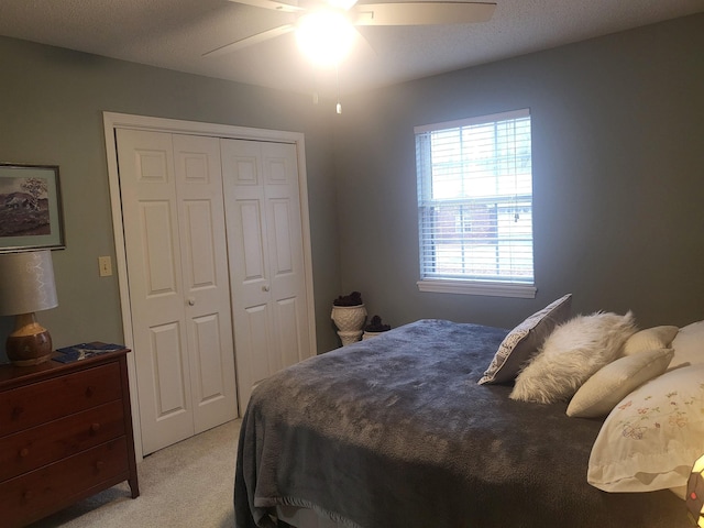 bedroom featuring light carpet, a closet, and ceiling fan