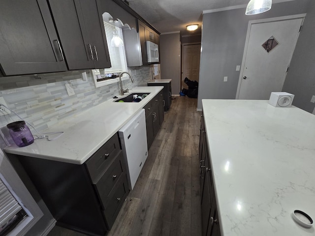 kitchen with pendant lighting, sink, dark hardwood / wood-style flooring, decorative backsplash, and white appliances