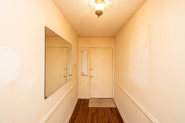 hall featuring dark hardwood / wood-style floors and a textured ceiling