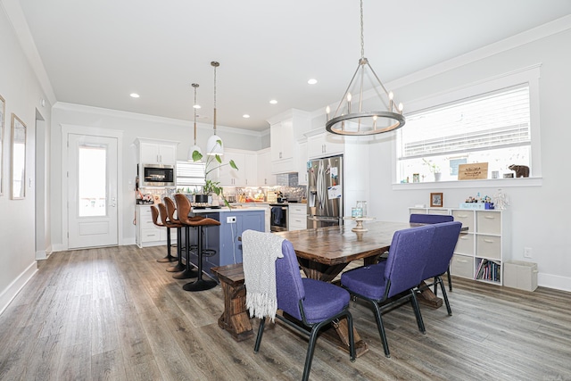 dining room with ornamental molding, light hardwood / wood-style floors, and a chandelier