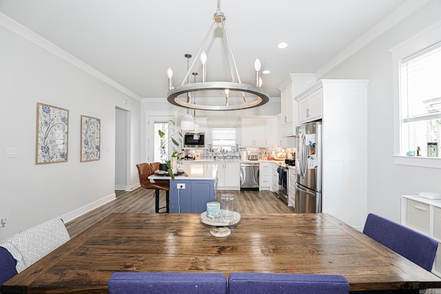 dining room with hardwood / wood-style flooring, crown molding, and a chandelier