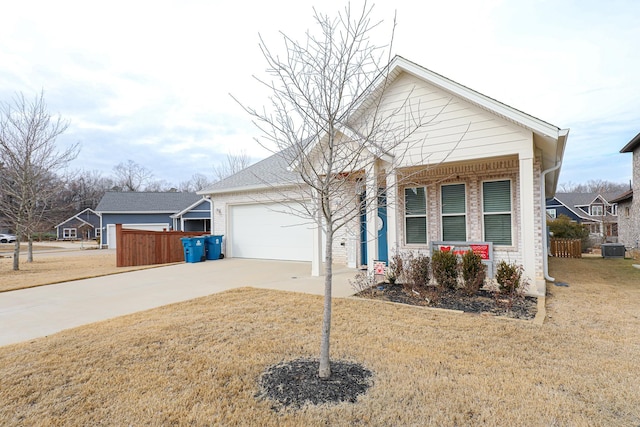 view of front of property with a garage, a front yard, and central air condition unit