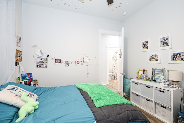 bedroom with connected bathroom, hardwood / wood-style flooring, and ceiling fan