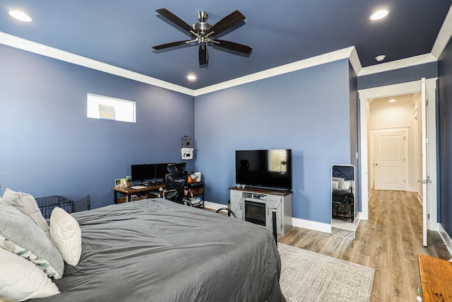 bedroom featuring light hardwood / wood-style flooring, ornamental molding, and ceiling fan