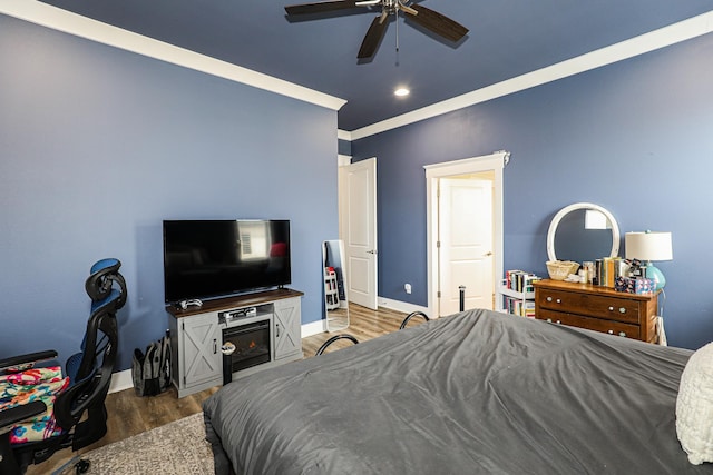 bedroom with crown molding, ceiling fan, and dark hardwood / wood-style flooring