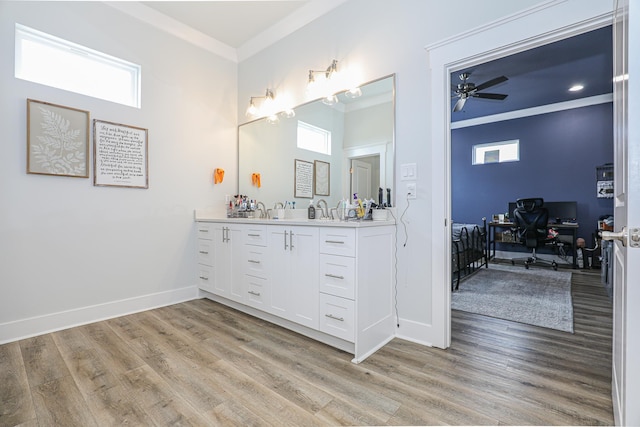 bathroom with ornamental molding, hardwood / wood-style floors, vanity, and ceiling fan