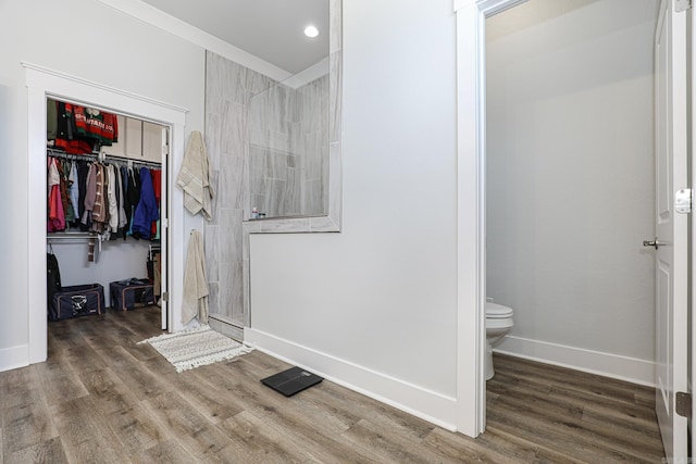 bathroom with toilet, hardwood / wood-style floors, and walk in shower