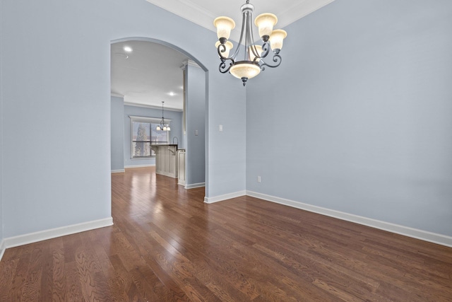 spare room with ornamental molding, dark hardwood / wood-style floors, and a notable chandelier