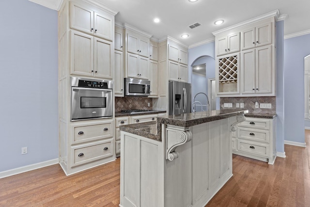 kitchen featuring a kitchen breakfast bar, appliances with stainless steel finishes, white cabinets, and a kitchen island