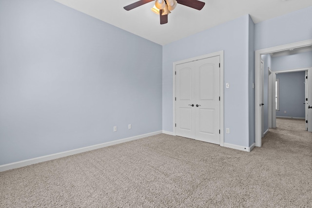 unfurnished bedroom with light colored carpet, a closet, and ceiling fan