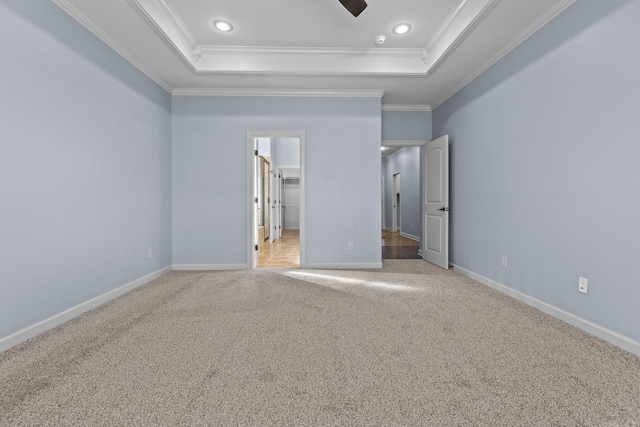 unfurnished bedroom featuring carpet floors, ornamental molding, and a raised ceiling